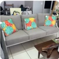 Sofá Pacífico gris con cojines de diseño tropical